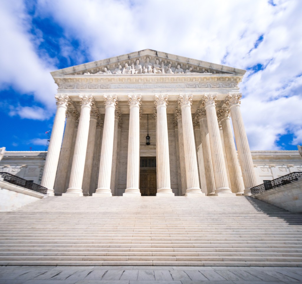 Marble stairs leading up towards the imposing entrance to the Supreme Court of the United States in Washington DC, USA.