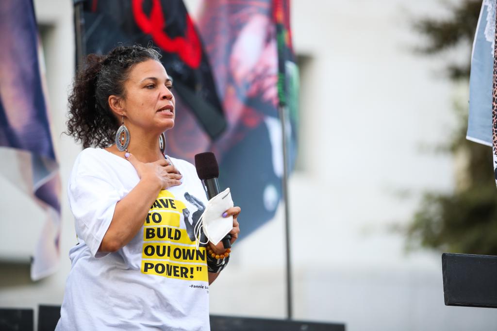 BLM activist Melina Abdullah holding a microphone at a protest