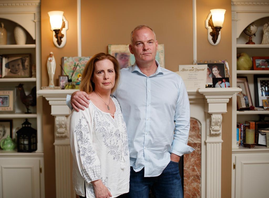 Michael McMahon and his wife Martha Byrne in front of a fireplace