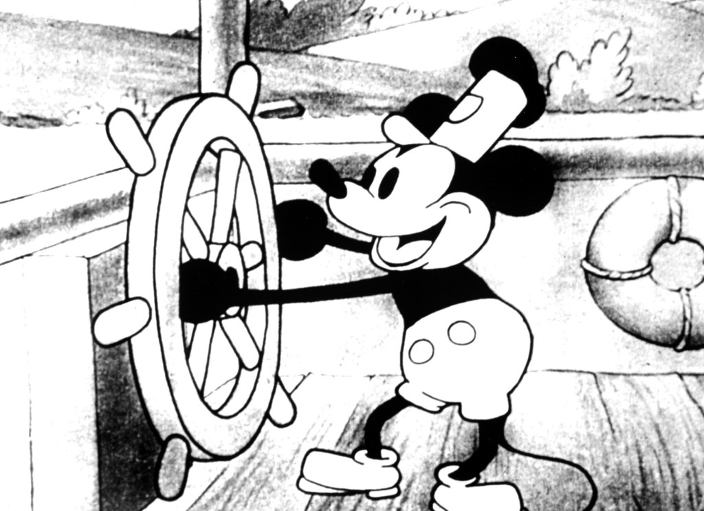 Mickey Mouse smiling and steering a boat. 