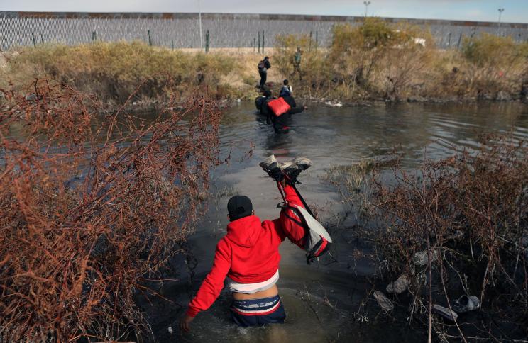 Migrants cross the Rio Bravo river, known as Rio Grande in the United States, into the US through Ciudad Juarez, Chihuahua State, Mexico