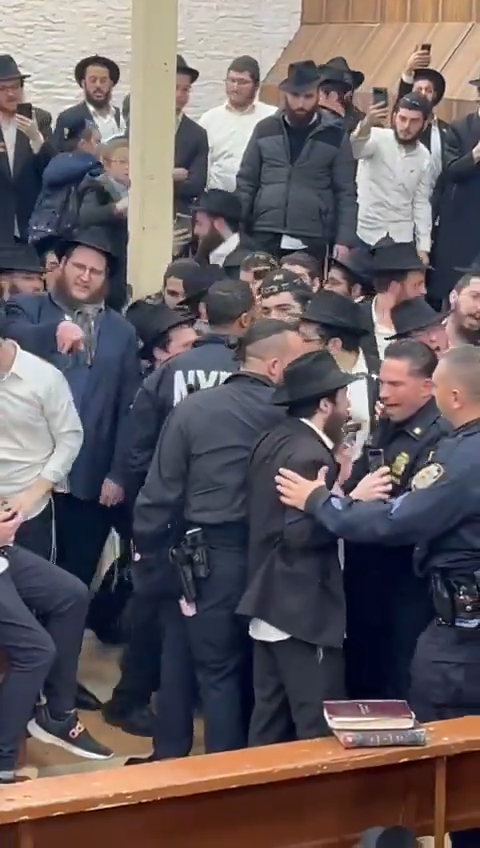 Cops are pictured arguing with the men.