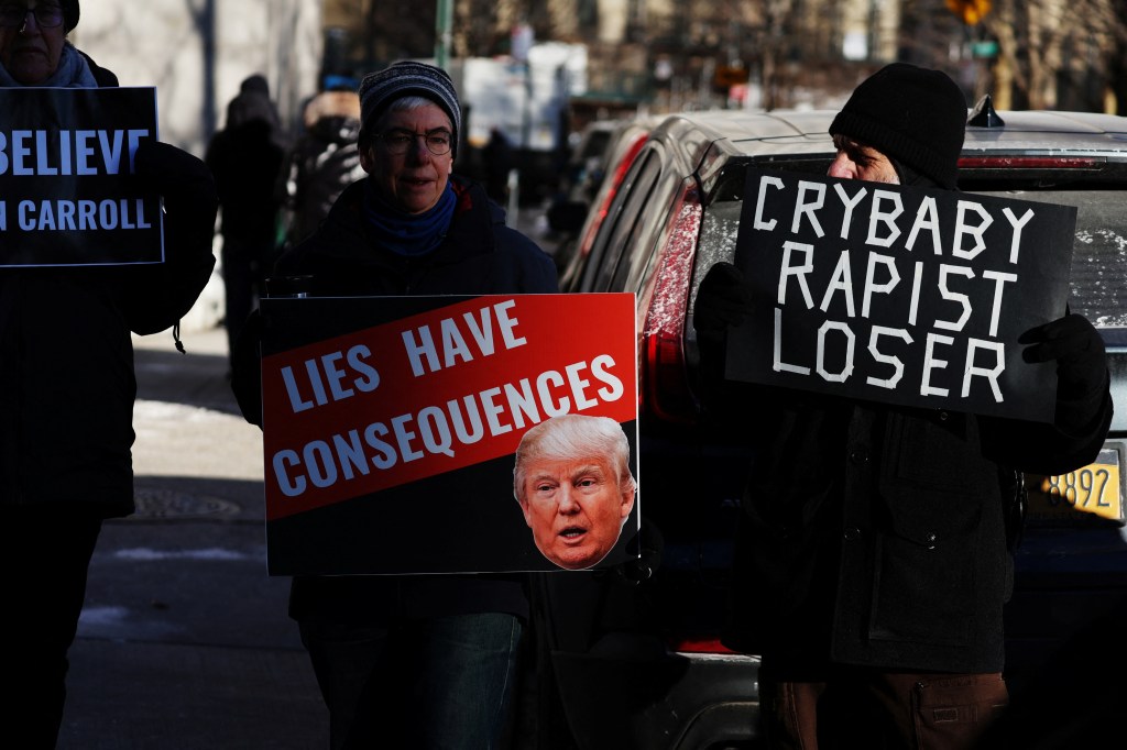 People demonstrate holding signs outside Manhattan Federal Court as former US President Donald Trump arrives for his E. Jean Carroll second civil trial.