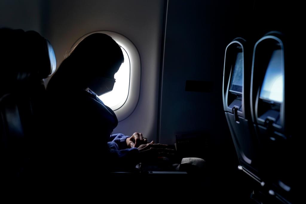 A person wearing a face mask sits on a flight, as seen in a photo taken at Hartsfield-Jackson International Airport in Atlanta.