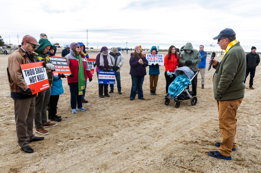 Rev. Mike Hollomon of Caldwell United Methodist and Emmett United Methodist prays with protesters against the death penalty outside of the Idaho Maximum Security Institution.