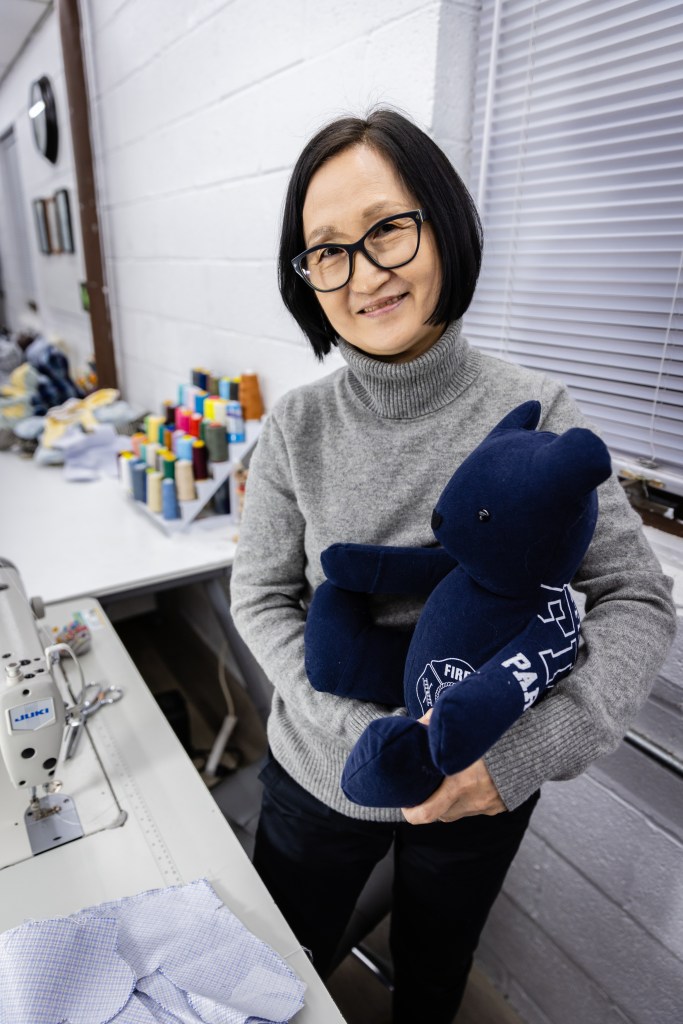 A woman at her studio with a stuffed animal.