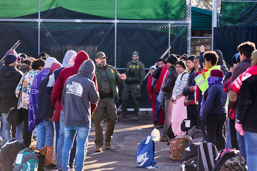 Migrants gather to be processed and transported outside a  U.S. Customs and Border Protection station