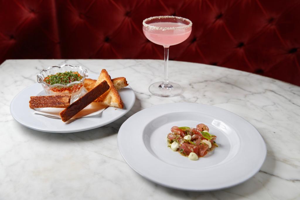 A cocktail, tuna crudo and a smoke trout dish on a table at Smith & Mills. 