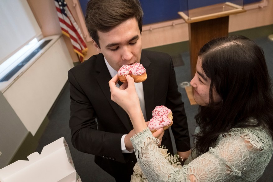 The couple celebrating with heart-shaped donuts.