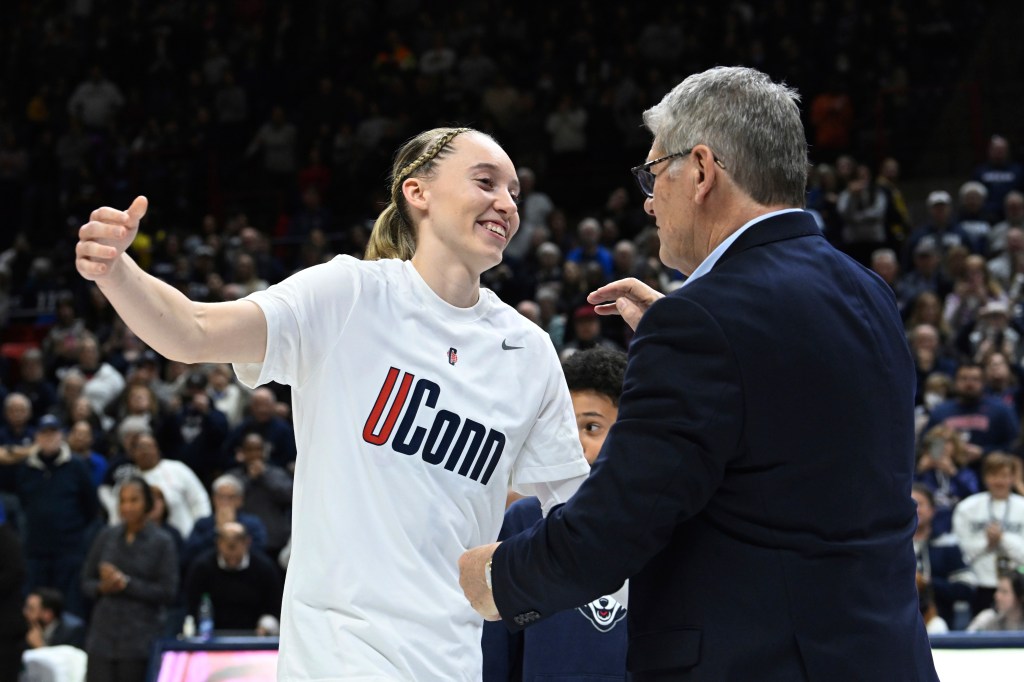 UConn guard Paige Bueckers (5) reaches for coach Geno Auriemma during senior night ceremonies after UConn defeated Georgetown