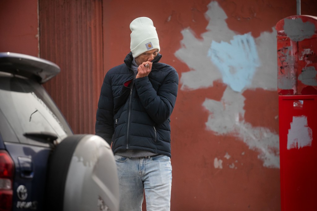 Angel Nunez covering his nose on corner of 6th Avenue and Prospect Avenue in Brooklyn borough of New York City