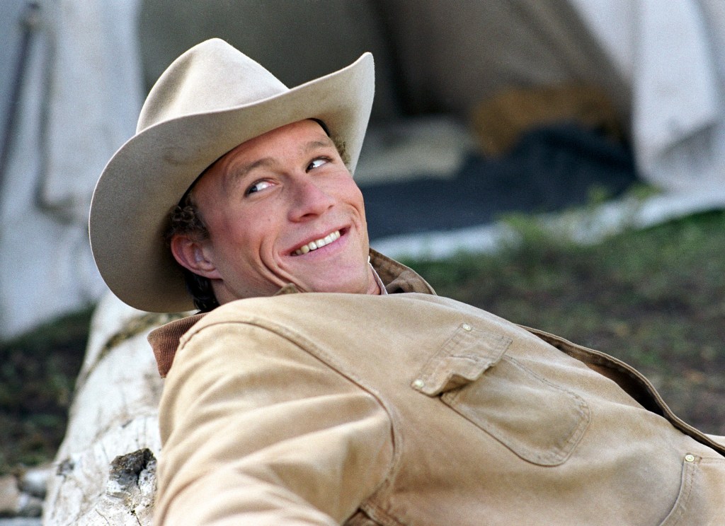 Heath Ledger smiling in a cowboy hat. 