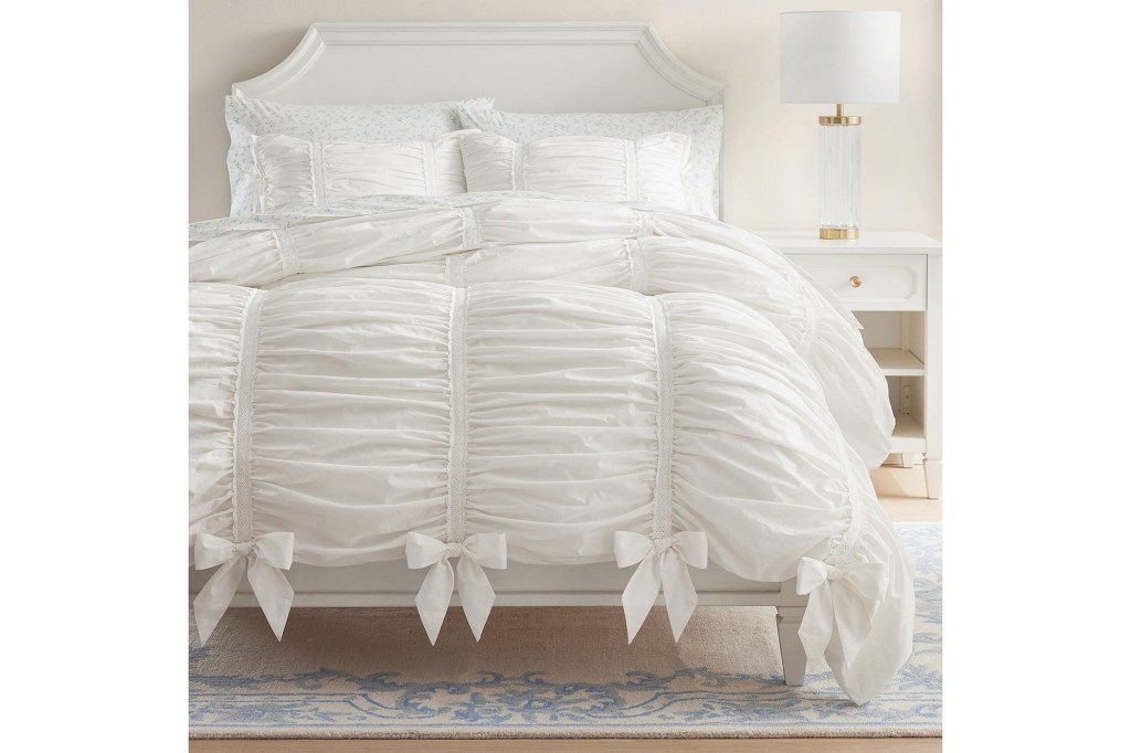 A bed with a white comforter and pillows