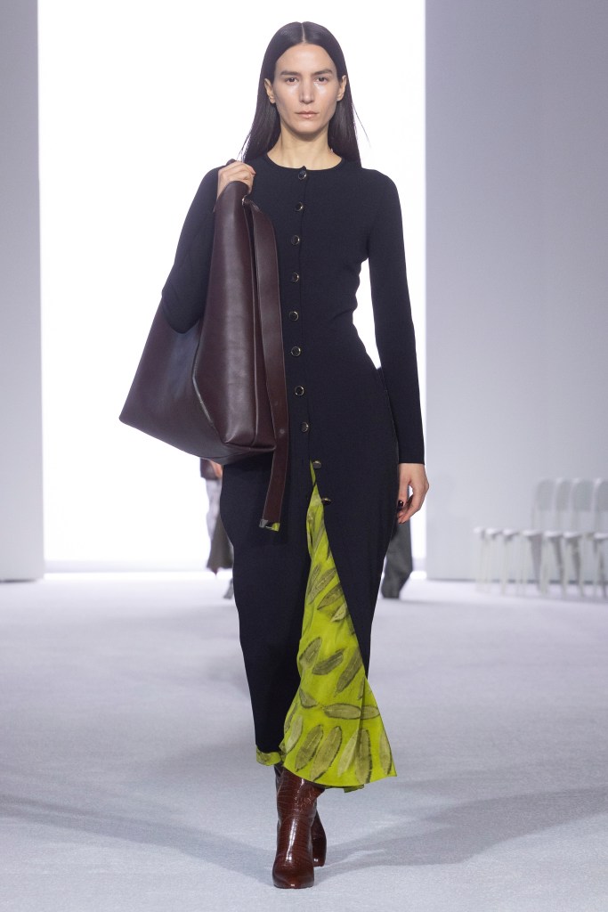 A Brandon Maxwell outfit combines a long black cardigan and a green skirt