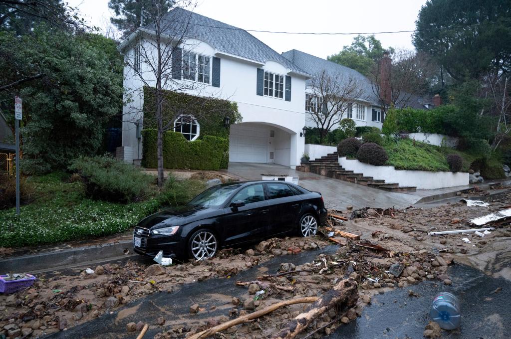 A car damages from mud, rock and debris flows along Fryman Road