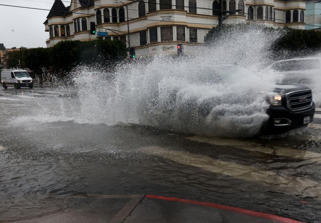 Cars drive on flooded streets, during the ongoing rain storm in Studio City, California