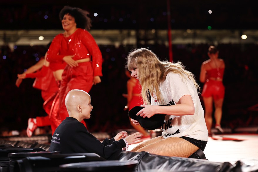 A young fan receives a hat from Taylor Swift during her performance at Accor Stadium in Sydney, Australia.