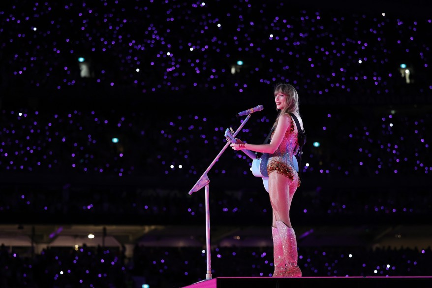 Taylor Swift performing on stage with a microphone during The Eras Tour at Accor Stadium in Sydney, Australia on February 23, 2024.