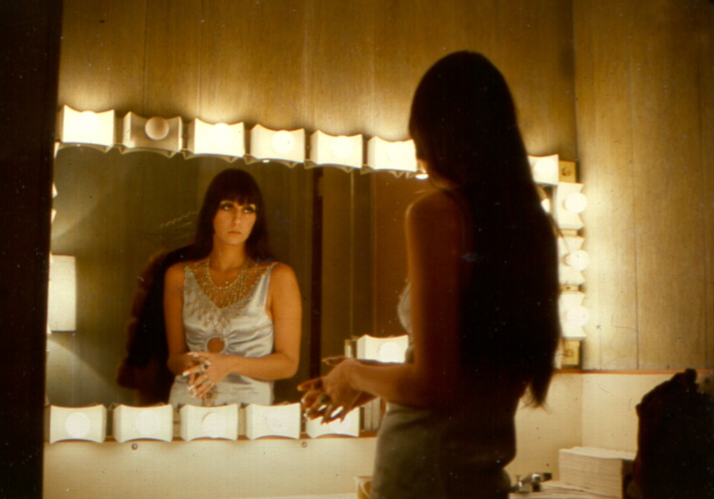 Cher fixing makeup in a backstage dressing room mirror in Los Angeles, California in March 1968.