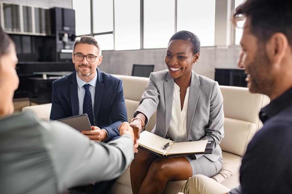 A smiling black businesswoman shakes hands with a new client in a modern office setting.