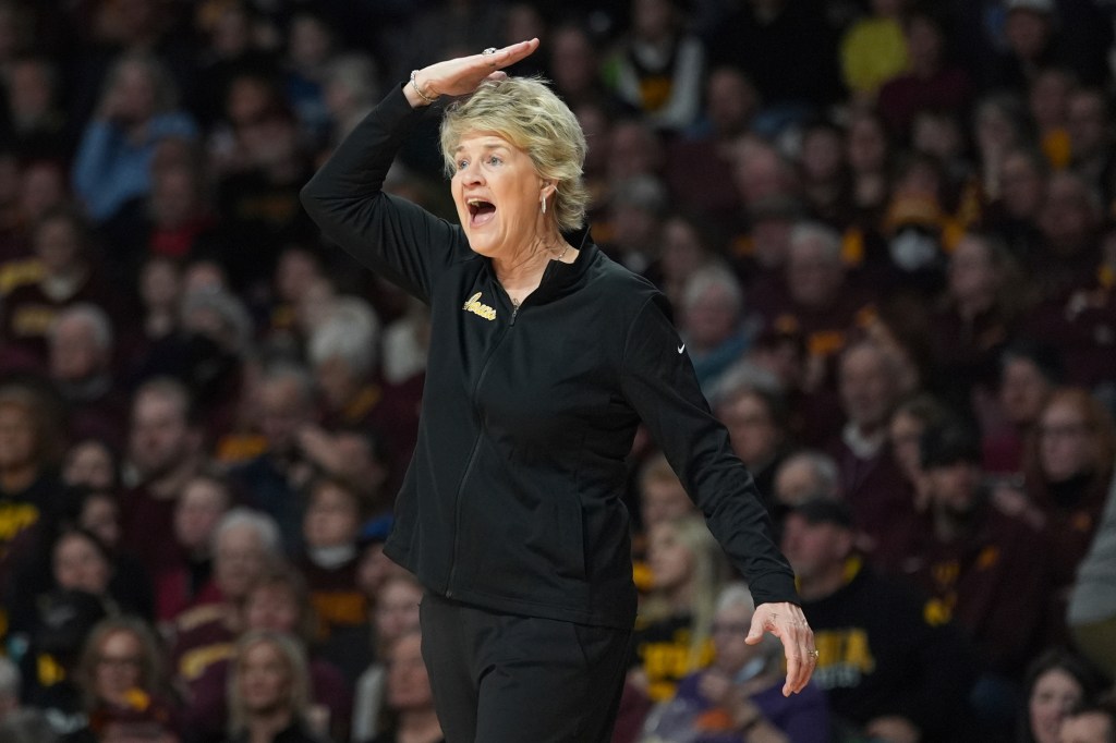 Iowa head coach Lisa Bluder gesturing during basketball game against Minnesota.