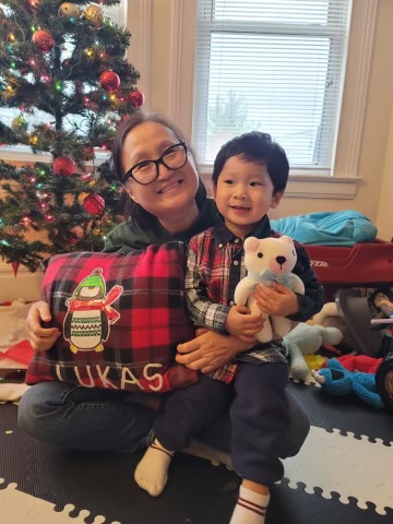 Jin with her grandson Lukas and a pillow she made him for Christmas.
