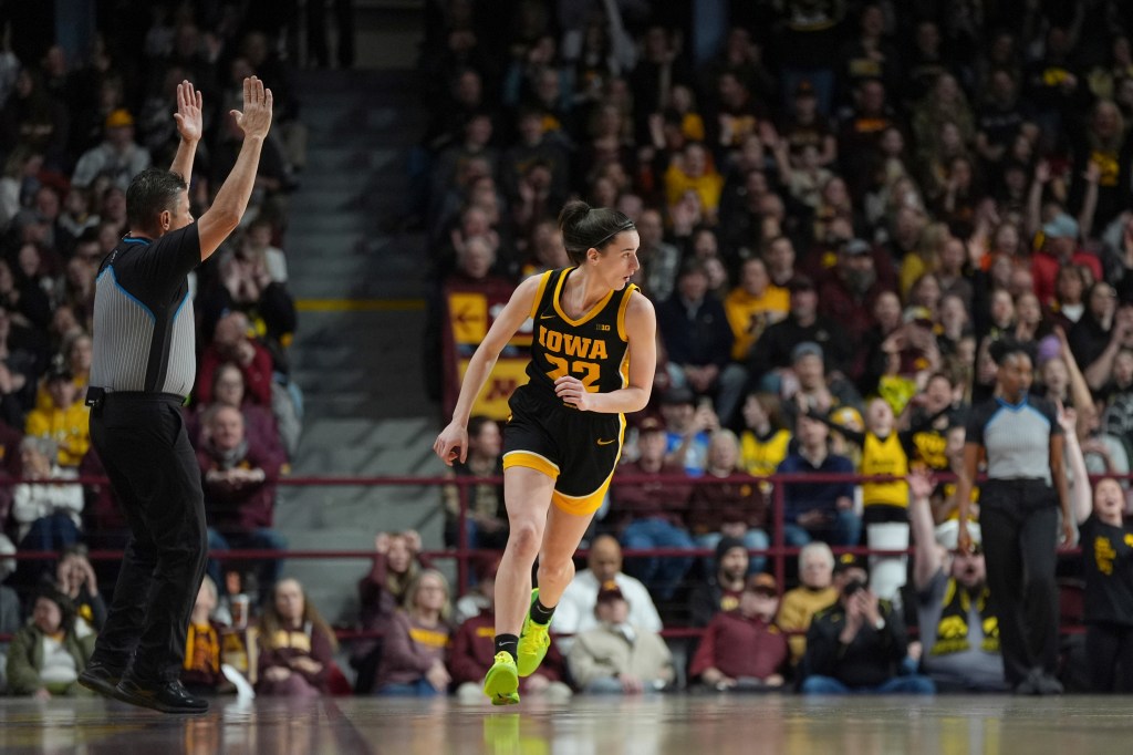 Caitlin Clark of Iowa jogs down the court after making a 3-point basket against Minnesota during an NCAA college basketball game.