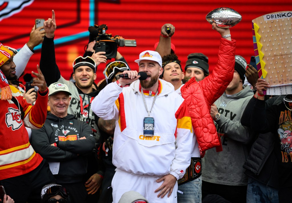 Chiefs tight end Travis Kelce, center, is cheered on by Patrick Mahomes, back right, while giving a speech during the Chiefs' victory celebration