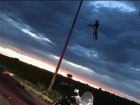 Kenney Littledike hangs from a power line following a car crash where she was ejected and thrown in the air.