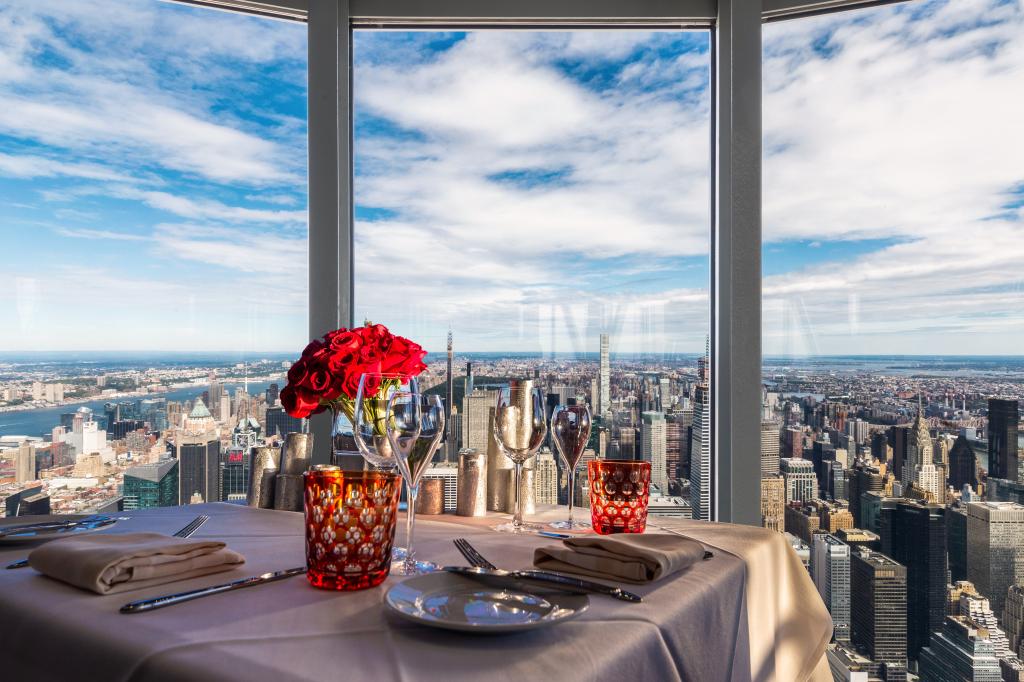 Image of a table for two in front of the New York skyline.