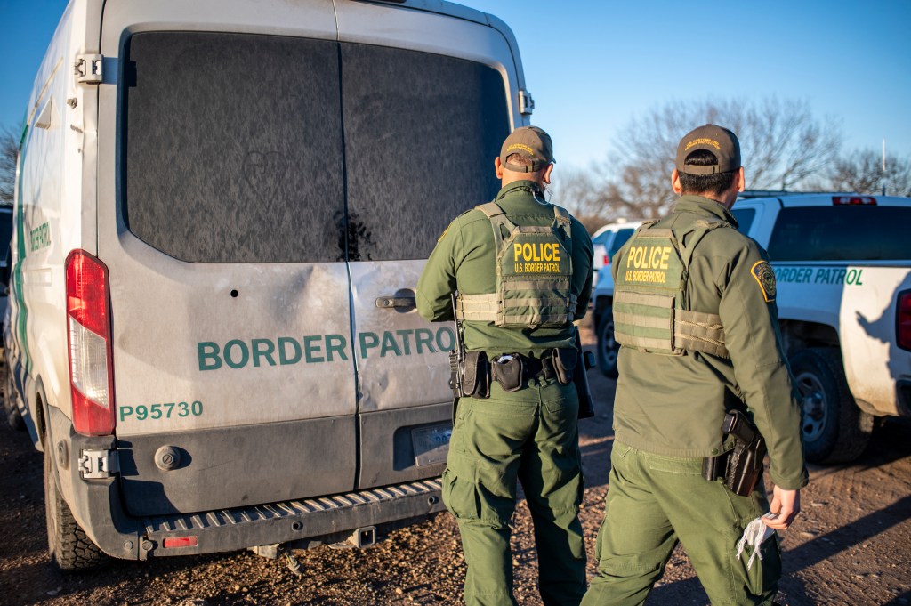 Border Patrol processes a group of about 60 migrants near the highway on February 4, 2024 outside Eagle Pass, Texas. Eagle Pass, about 20 miles (30 kilometers) from Quemado, has become the epicenter of a prickly conflict between Texas Governor Greg Abbott, a Republican, and the Biden administration. The federal government is suing Abbott for taking control of Shelby Park that includes an access ramp to the river, and for laying barbed wire along the riverbank. (Photo by SERGIO FLORES / AFP) (Photo by SERGIO FLORES/AFP via Getty Images)
