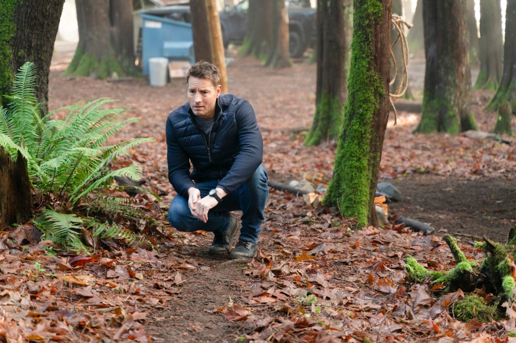 Justin Hartley crouching on the ground. 