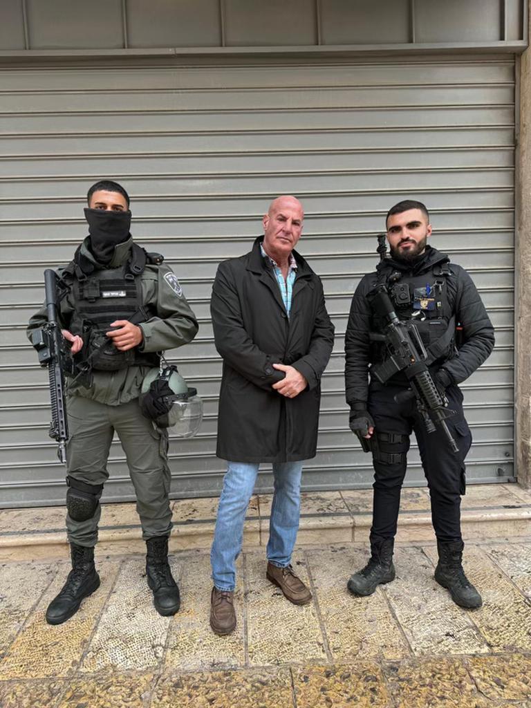 Man standing with two armed soldiers