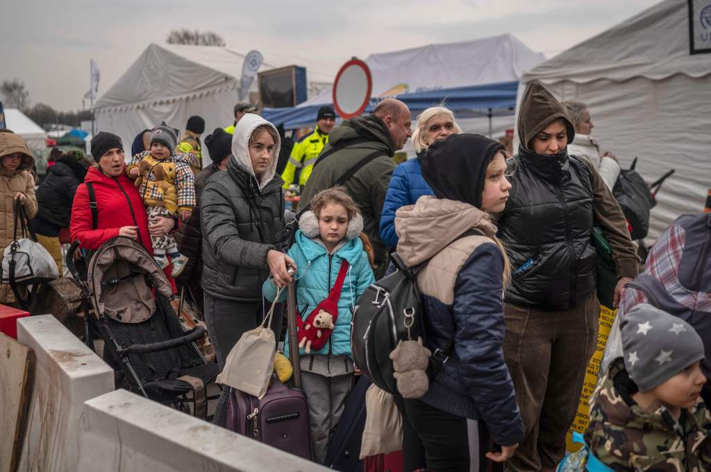 Ukrainian evacuees standing in a queue as they wait for further transportation at Medyka border crossing, southeastern Poland.