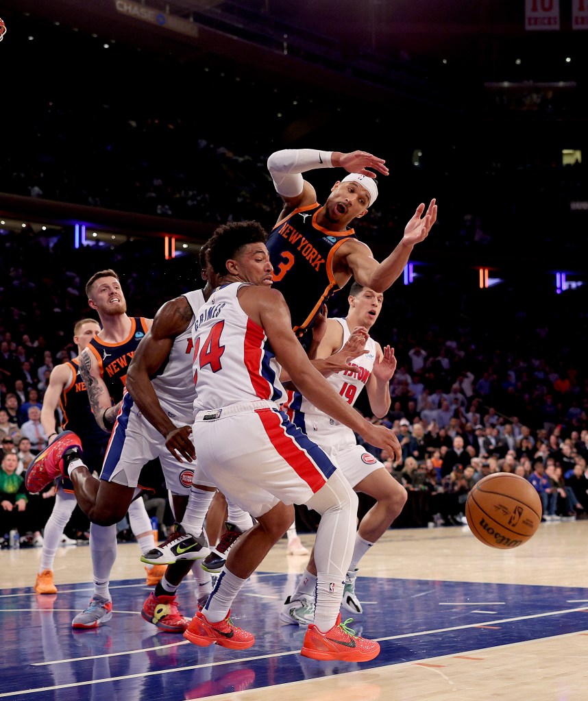 Josh Hart loses control of the ball as Quentin Grimes #24 and Simone Fontecchio #19 of the Detroit Pistons defend.