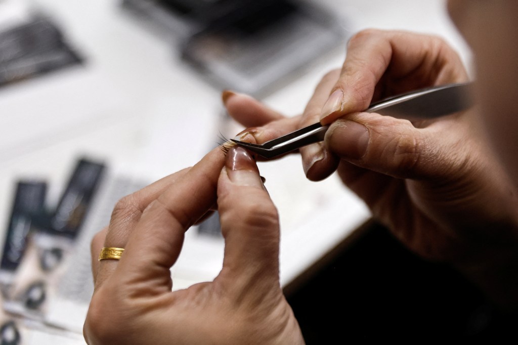 A woman making fake eyelashes. 