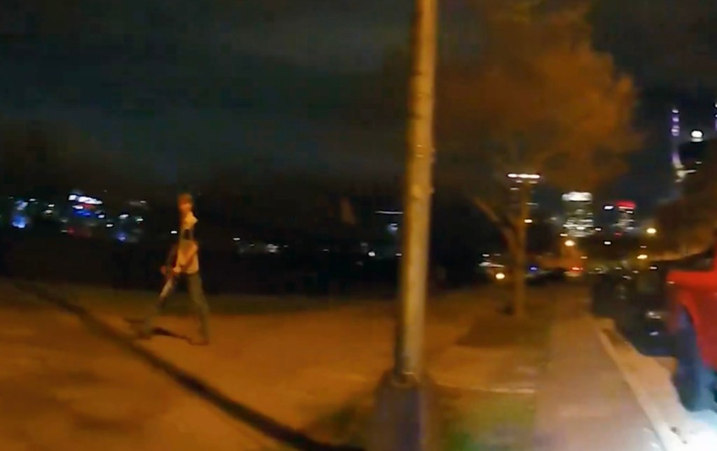 Strain is seen walking past a Nashville police officer in body cam footage.