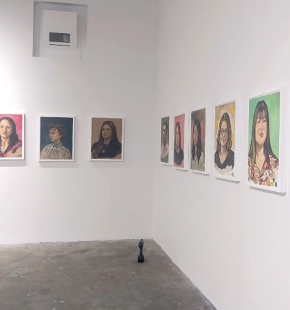 The gallery wall with the portraits. 