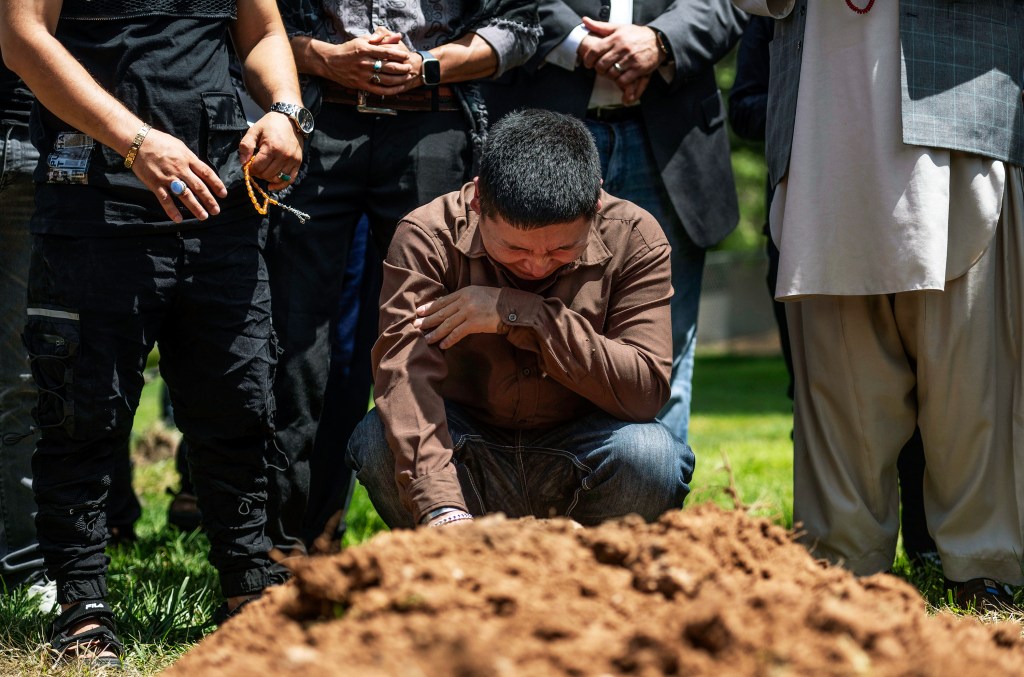 Altaf Hussain cries over the grave of his brother Aftab Hussein at Fairview Memorial Park in Albuquerque