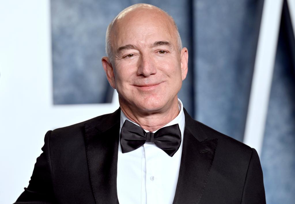 Jeff Bezos in a suit and bow tie, arriving at a party.