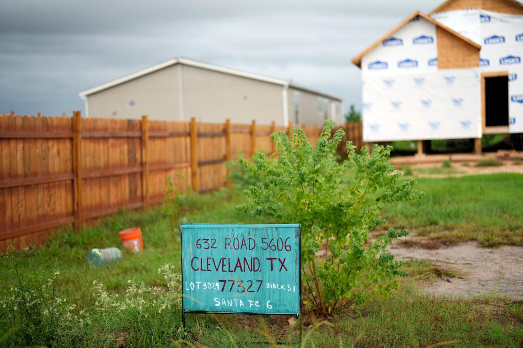 A new home under construction is shown next to a mobile home in the Colony Ridge development 