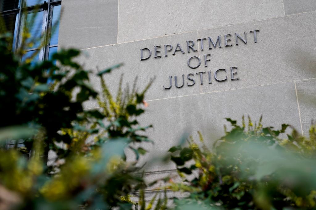 Signage on the Robert F. Kennedy Department of Justice Building with plants out of focus