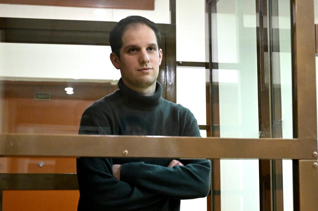 Wall Street Journal reporter Evan Gershkovich stands in a glass cage in a courtroom at the Moscow City Court, in Moscow, Russia