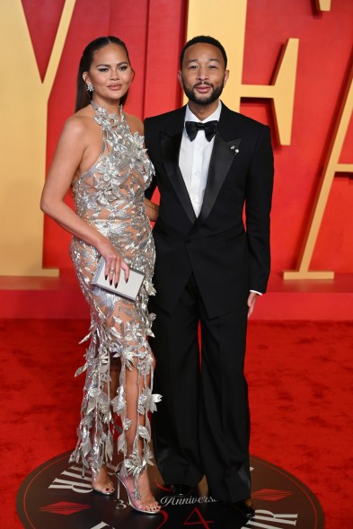 Chrissy Teigen and John Legend attending the 2024 Vanity Fair Oscar Party hosted by Radhika Jones on a red carpet at Wallis Annenberg Center.