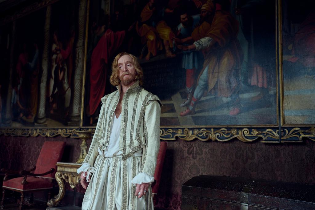 Tony Curran standing in front of a painting. 