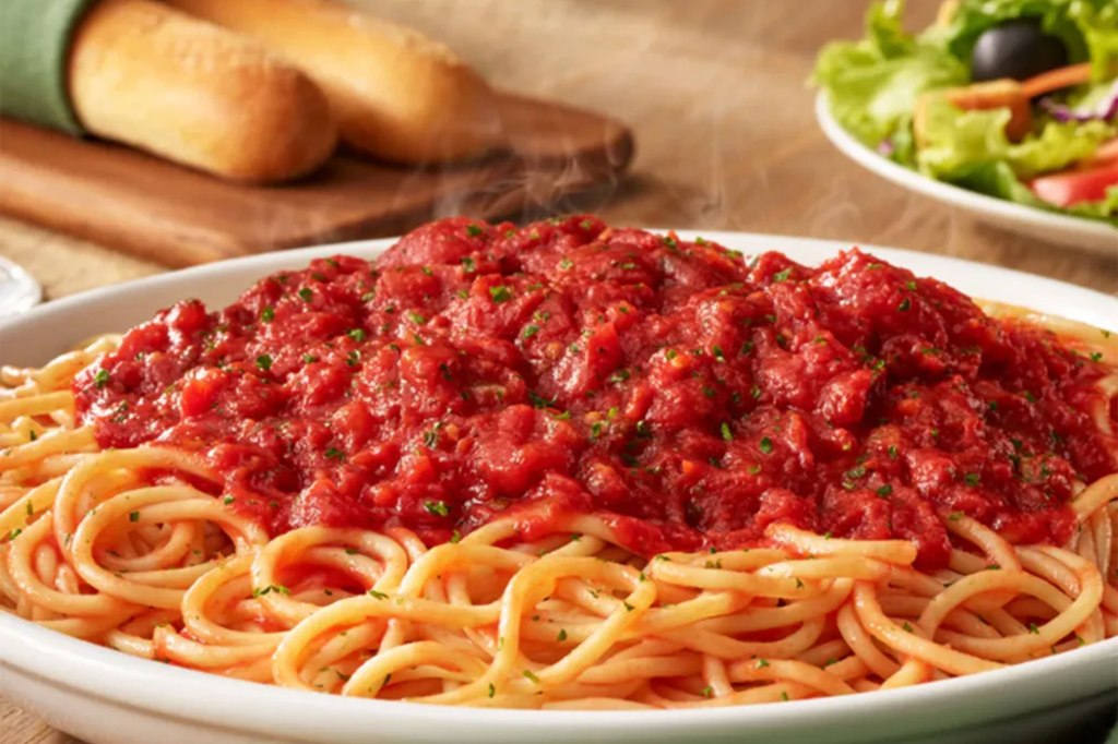 A plate of spaghetti with sauce at a popular Olive Garden branch