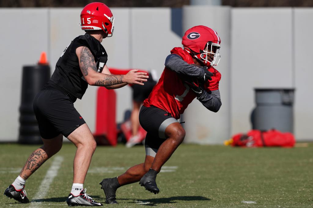 Georgia running back Trevor Etienne (1) takes a handoff from Georgia quarterback Carson Beck (15) during spring practice in Athens, Ga., on March 4.