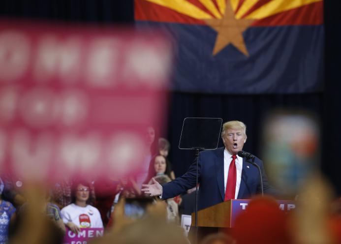 Donald Trump speaking at a podium during a rally at the Phoenix Convention Center in October 2016.