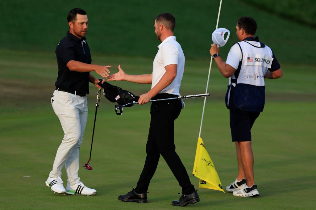 Xander Schauffele (left) shakes hands with Wyndham Clark after both players completed the third round at the Players Championship. 