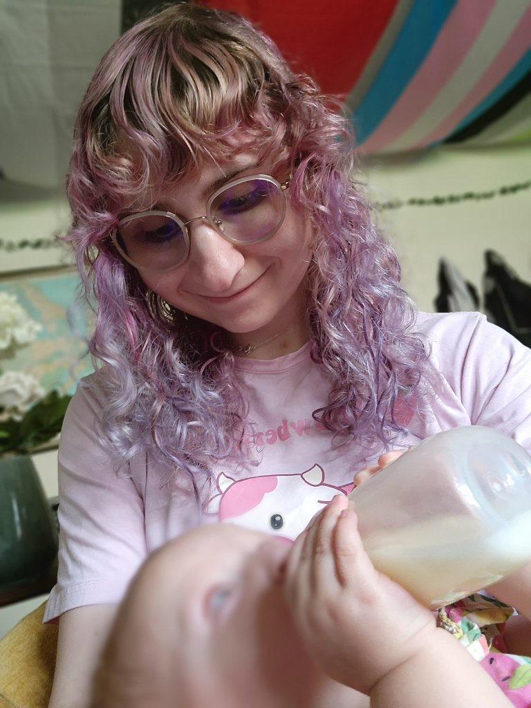 A transgender woman is pictured feeding her child.